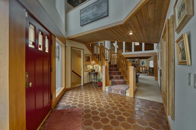 foyer entrance with a high ceiling and wooden ceiling