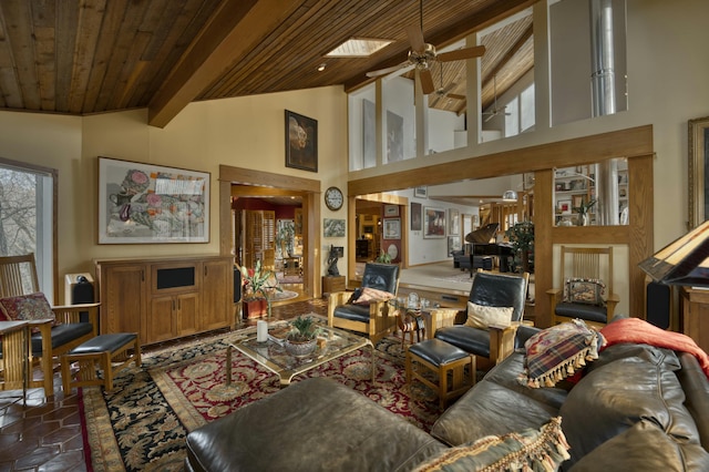 tiled living room featuring ceiling fan, beam ceiling, a skylight, high vaulted ceiling, and wooden ceiling