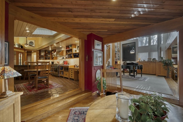 dining area with wooden ceiling, a skylight, hardwood / wood-style floors, and beamed ceiling