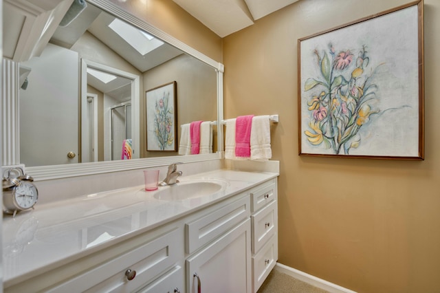 bathroom with vanity and lofted ceiling with skylight