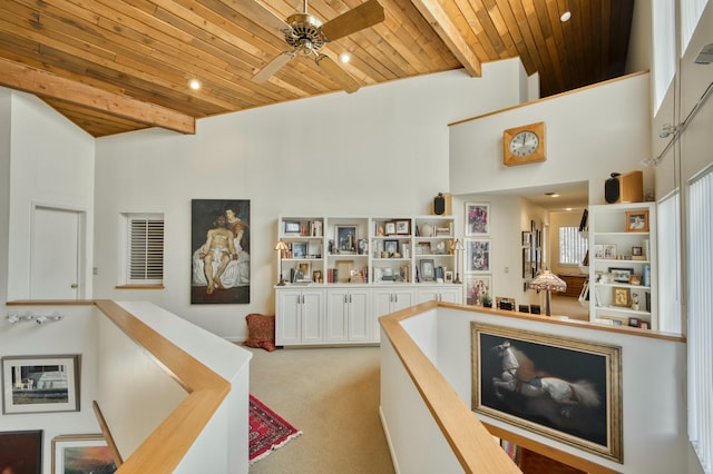 hallway with wooden ceiling, beam ceiling, and light colored carpet