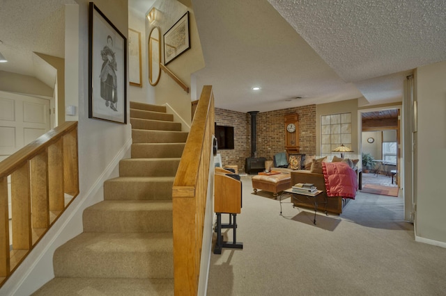 carpeted living room with a wood stove and a textured ceiling