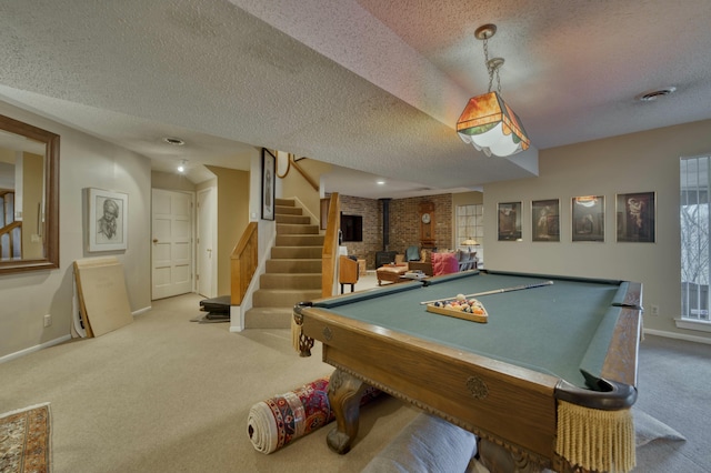 playroom with a wood stove, a textured ceiling, pool table, and carpet flooring