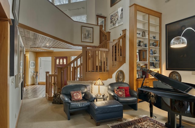 living area with light carpet, built in features, and a towering ceiling