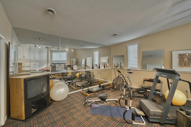 workout room featuring a textured ceiling