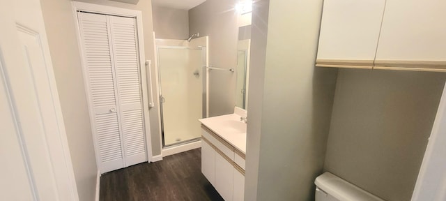 bathroom with vanity, a shower with shower door, toilet, and hardwood / wood-style flooring