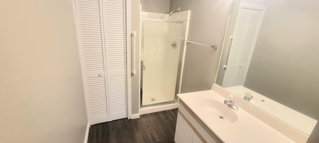 bathroom with a shower with door, vanity, and wood-type flooring