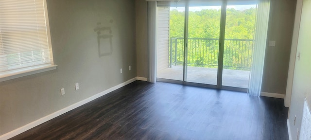 unfurnished room featuring dark hardwood / wood-style floors and a wealth of natural light