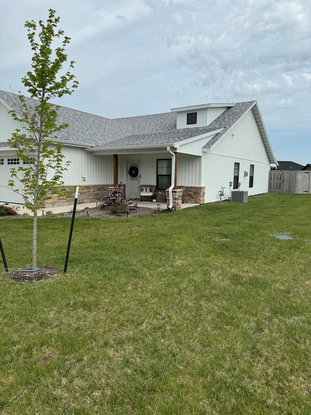 rear view of house with a patio, a yard, and central AC