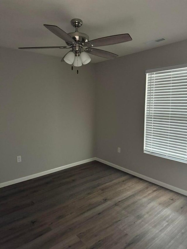 spare room featuring ceiling fan and dark wood-type flooring