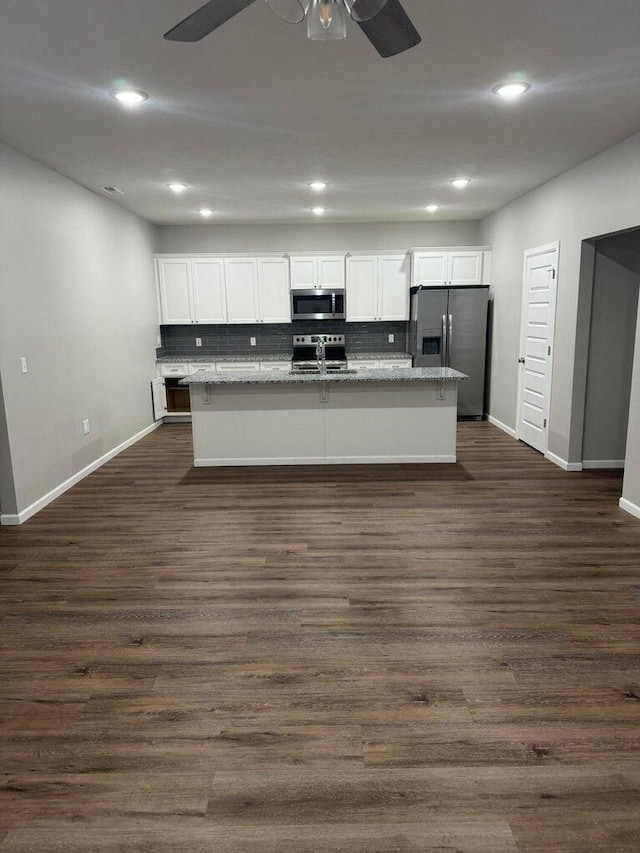 kitchen featuring appliances with stainless steel finishes, dark hardwood / wood-style flooring, and white cabinetry