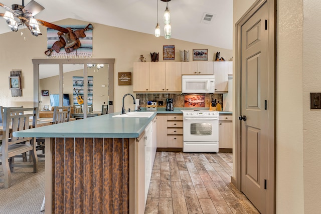 kitchen with sink, white appliances, vaulted ceiling, and light hardwood / wood-style floors