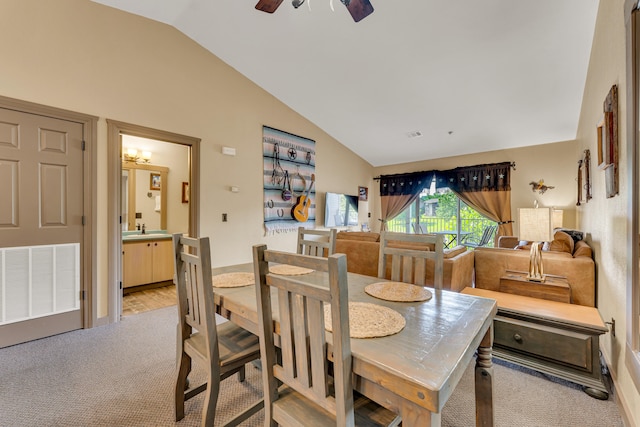 dining space featuring lofted ceiling, light hardwood / wood-style flooring, sink, and ceiling fan