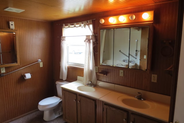 bathroom with vanity, wood walls, and toilet