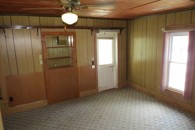 doorway to outside with wooden walls