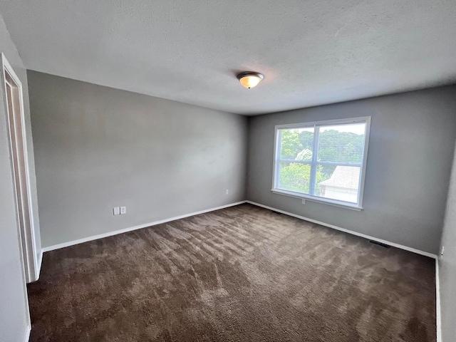 carpeted spare room featuring a textured ceiling