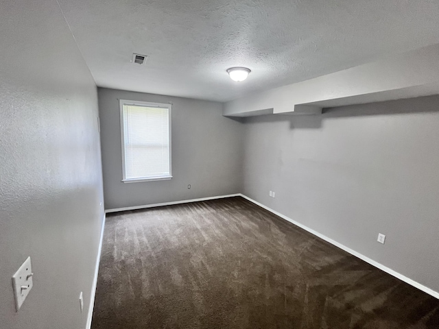 carpeted spare room with a textured ceiling