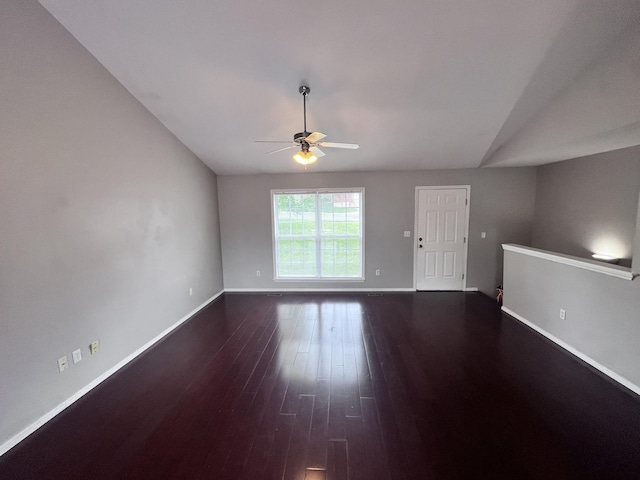 unfurnished living room featuring dark wood-type flooring and ceiling fan