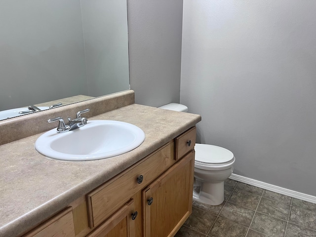 bathroom featuring vanity, tile patterned flooring, and toilet