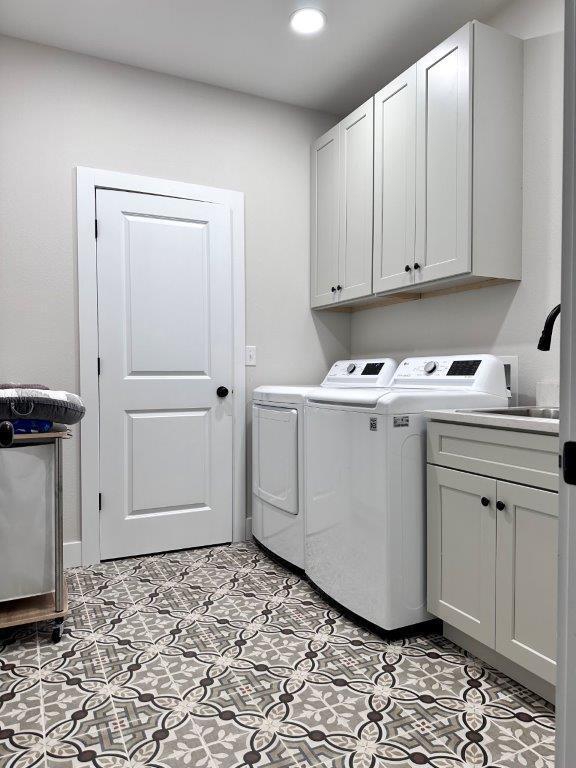 laundry room with cabinets and washer and clothes dryer