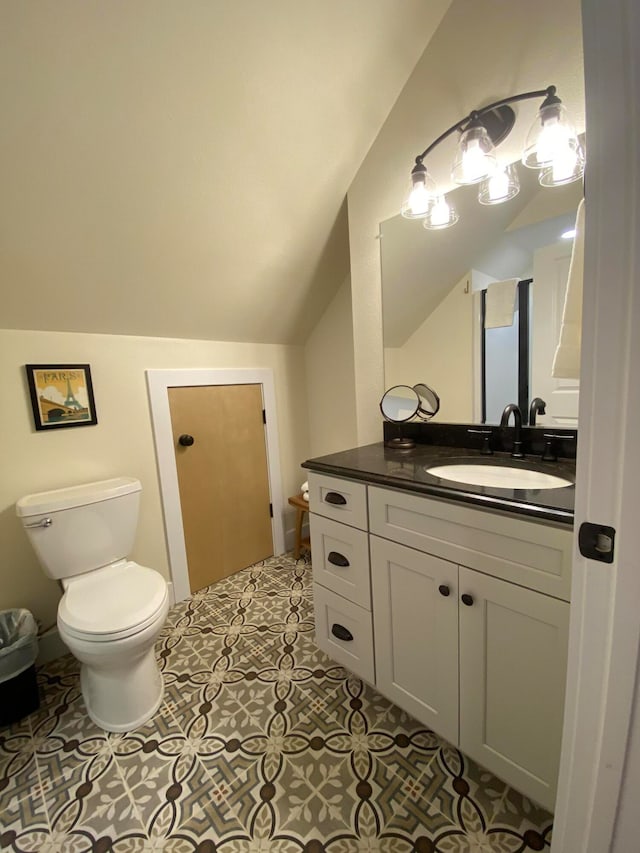 bathroom with vanity, lofted ceiling, tile patterned flooring, and toilet