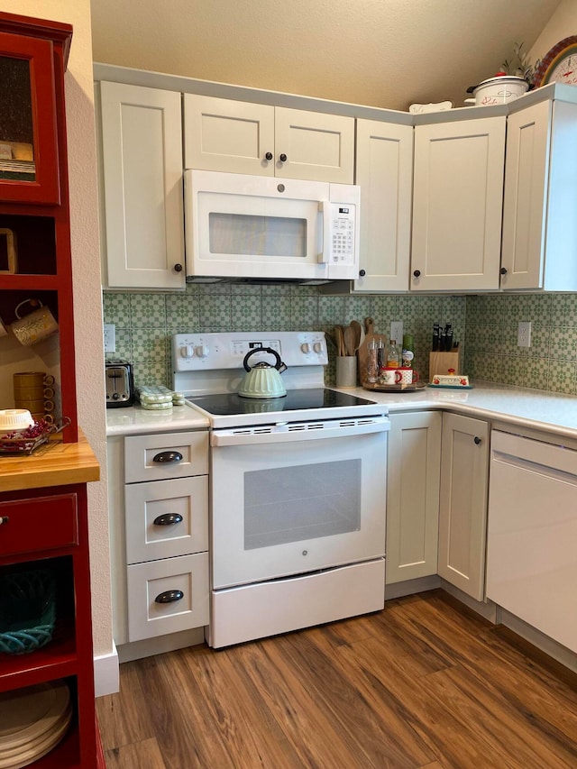 kitchen featuring tasteful backsplash, white appliances, dark hardwood / wood-style floors, and white cabinets