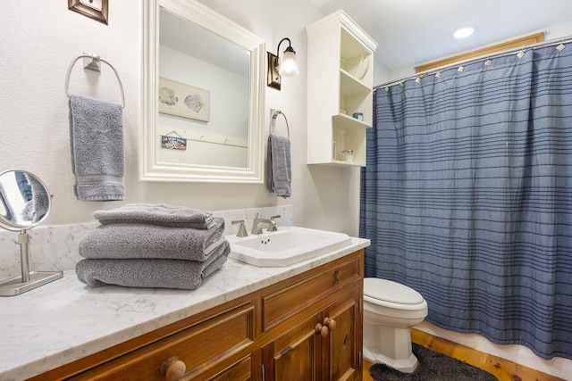 bathroom with toilet, vanity, and a shower with shower curtain