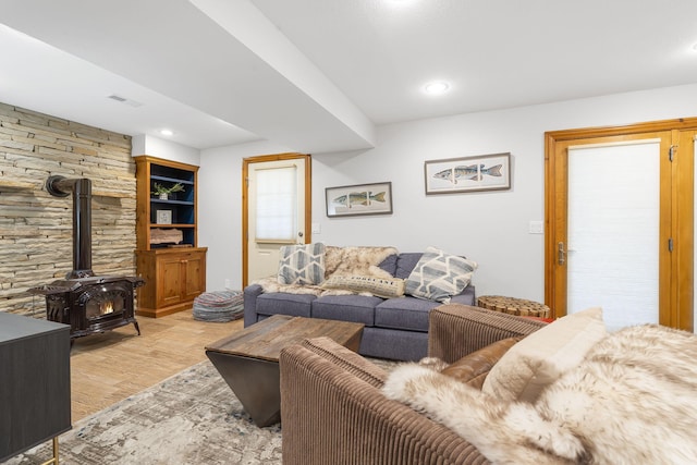 living room featuring light hardwood / wood-style flooring and a wood stove