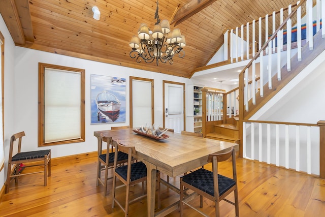 dining area featuring a notable chandelier, beam ceiling, wooden ceiling, and light hardwood / wood-style flooring