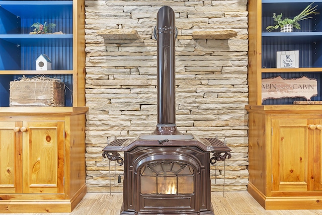 interior details featuring wood-type flooring and a wood stove