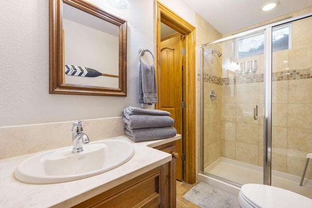 bathroom featuring an enclosed shower, vanity, and toilet