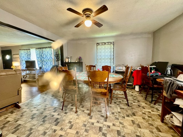 dining space featuring ceiling fan and a textured ceiling