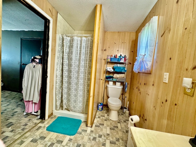 bathroom featuring a shower with curtain, a textured ceiling, wood walls, and toilet