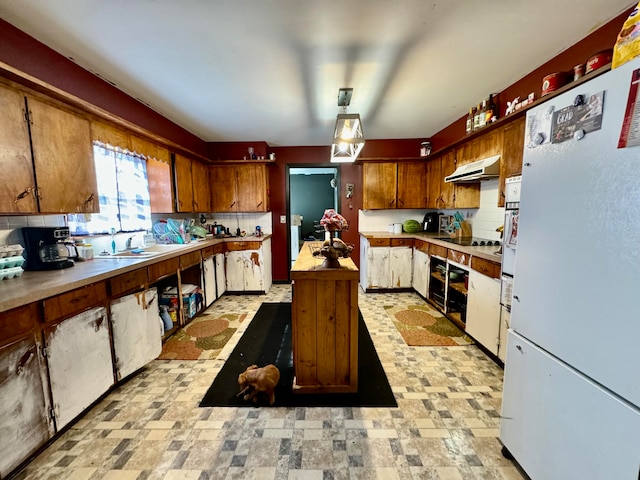 kitchen featuring exhaust hood, backsplash, and white fridge