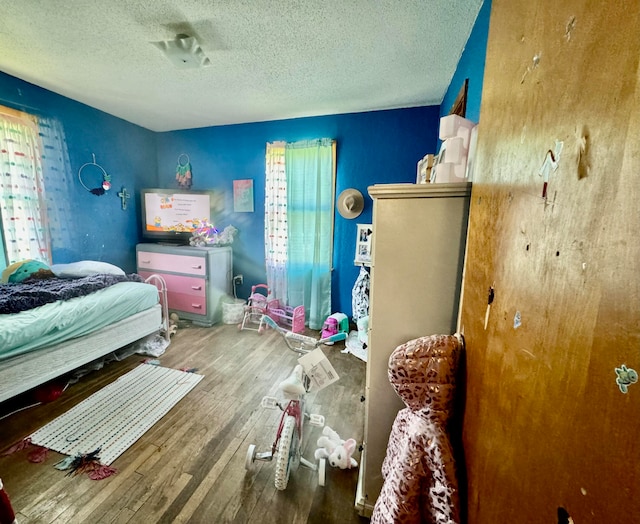 bedroom featuring hardwood / wood-style flooring and a textured ceiling