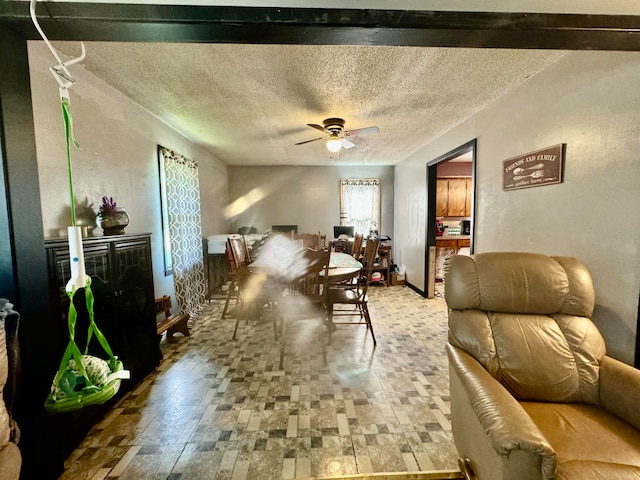 living room with ceiling fan and a textured ceiling