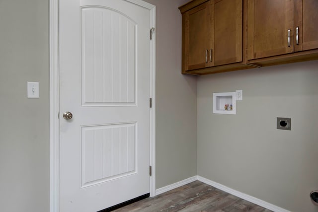 clothes washing area featuring hookup for a washing machine, electric dryer hookup, wood-type flooring, and cabinets