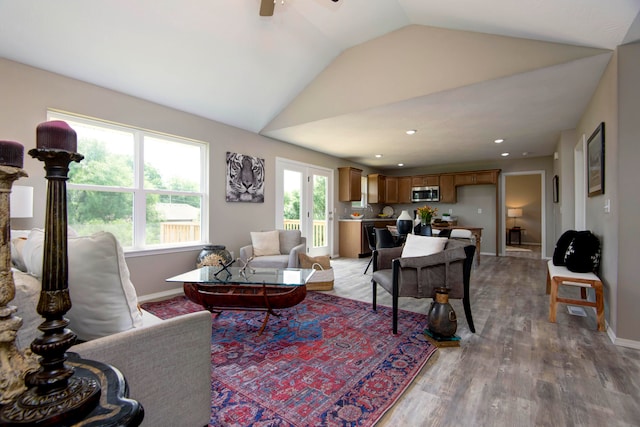 living room featuring hardwood / wood-style floors, ceiling fan, and vaulted ceiling