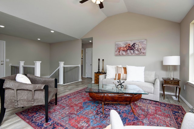 living room with vaulted ceiling, ceiling fan, and light hardwood / wood-style flooring