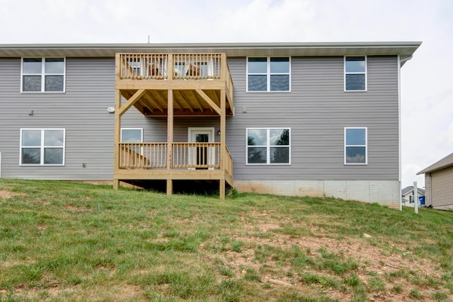 rear view of house with a balcony and a yard