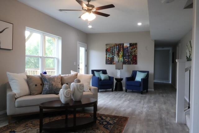 living room with hardwood / wood-style flooring and ceiling fan