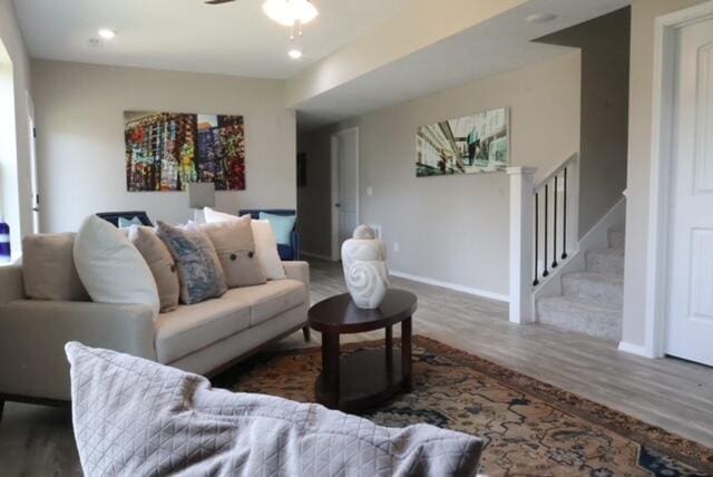 living room featuring dark wood-type flooring and ceiling fan