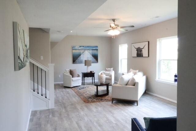 living room with light hardwood / wood-style flooring and ceiling fan