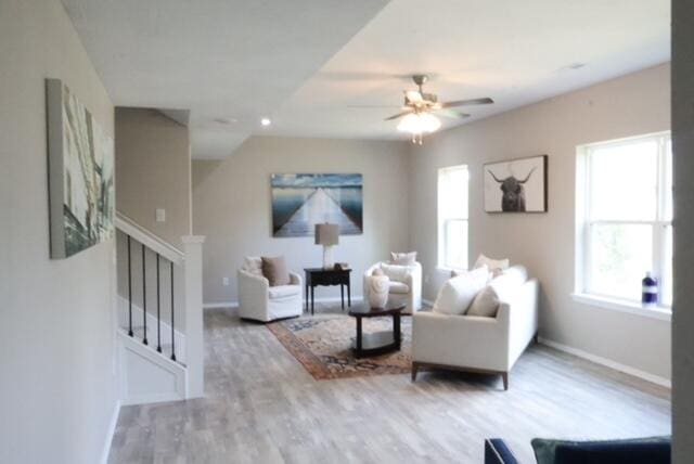 living room with ceiling fan and light hardwood / wood-style flooring