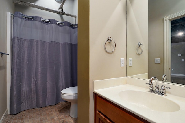 bathroom featuring toilet, vanity, and curtained shower