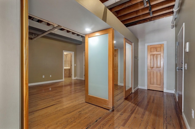 foyer entrance featuring wood-type flooring and beamed ceiling