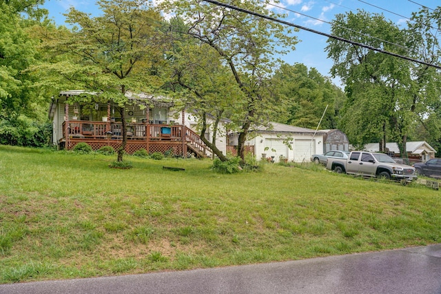 view of yard with a garage, a wooden deck, and an outbuilding