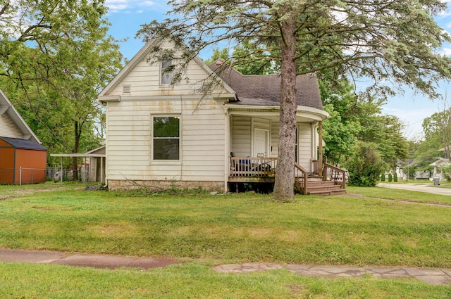 view of front of home with a storage shed and a front yard