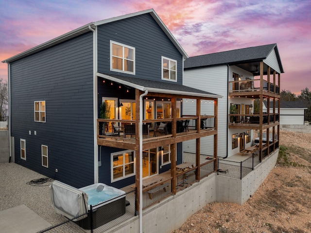 back house at dusk with a balcony and a patio area