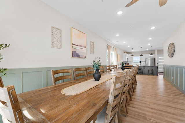 dining space with ceiling fan and light hardwood / wood-style flooring